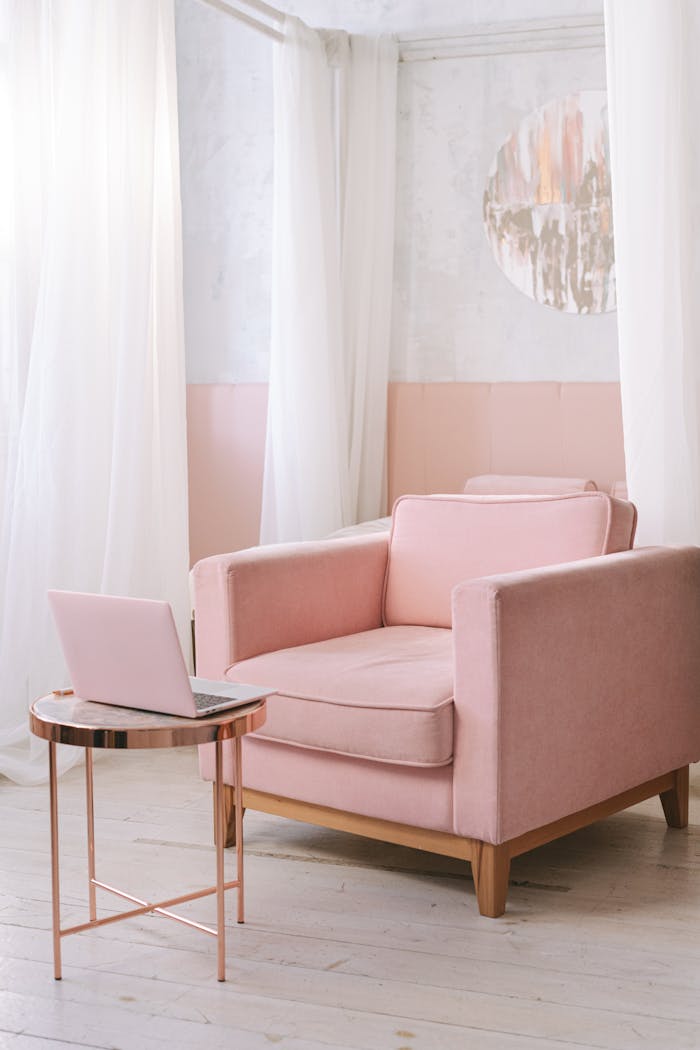 Crafting Captivating Headlines: Your awesome post title goes here A chic pink armchair in a bright, modern living room with a laptop on the side table.